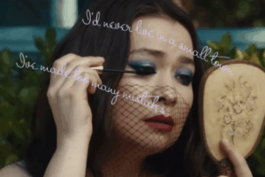 Mitski en el videclip "In a lake" maquillándose frente a un espejo.
